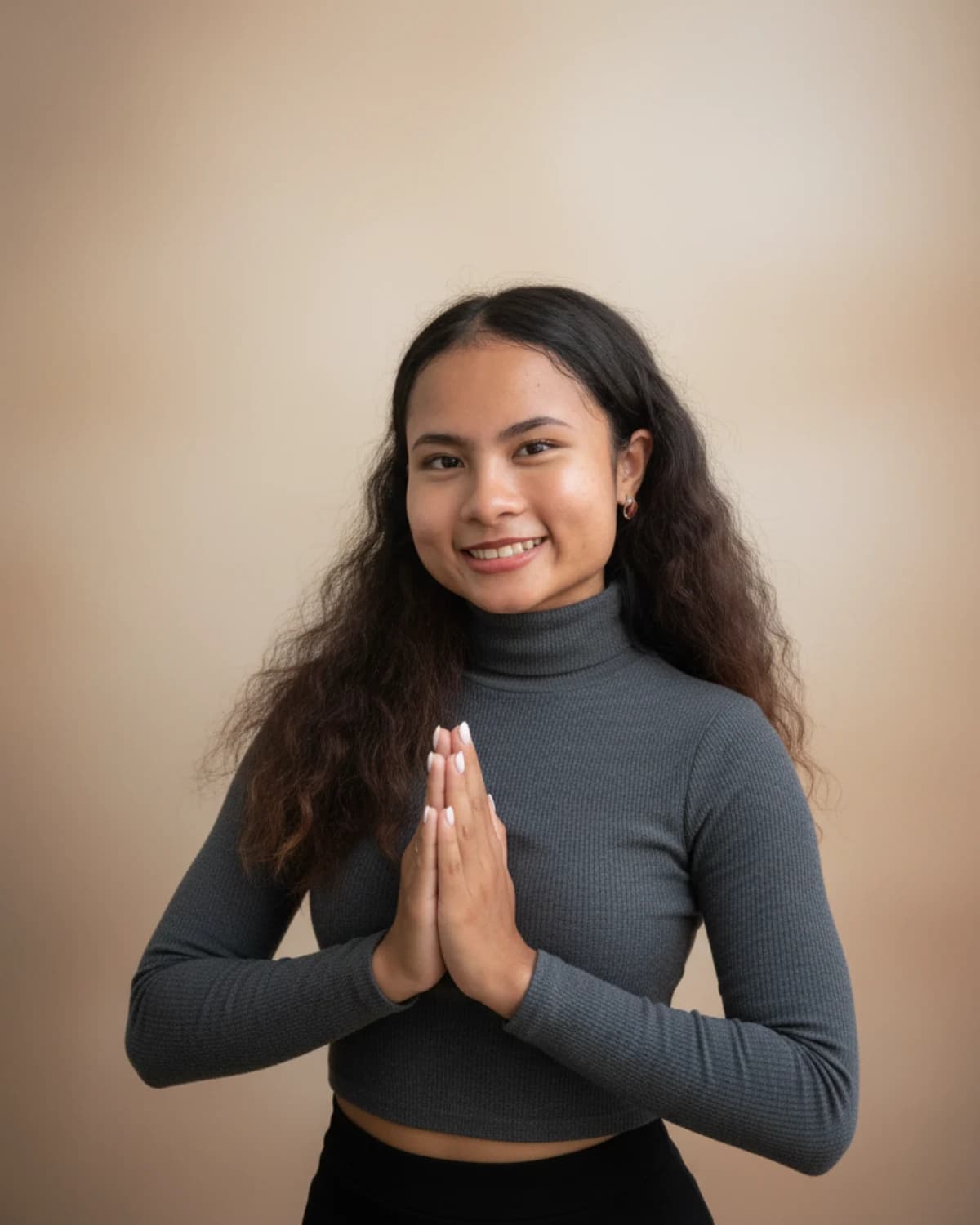 Kru Nariss smiling and greeting with a traditional Thai wai